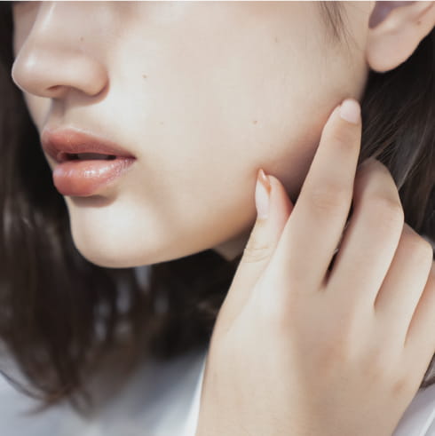 女性が手をほっぺに手を当てている画像